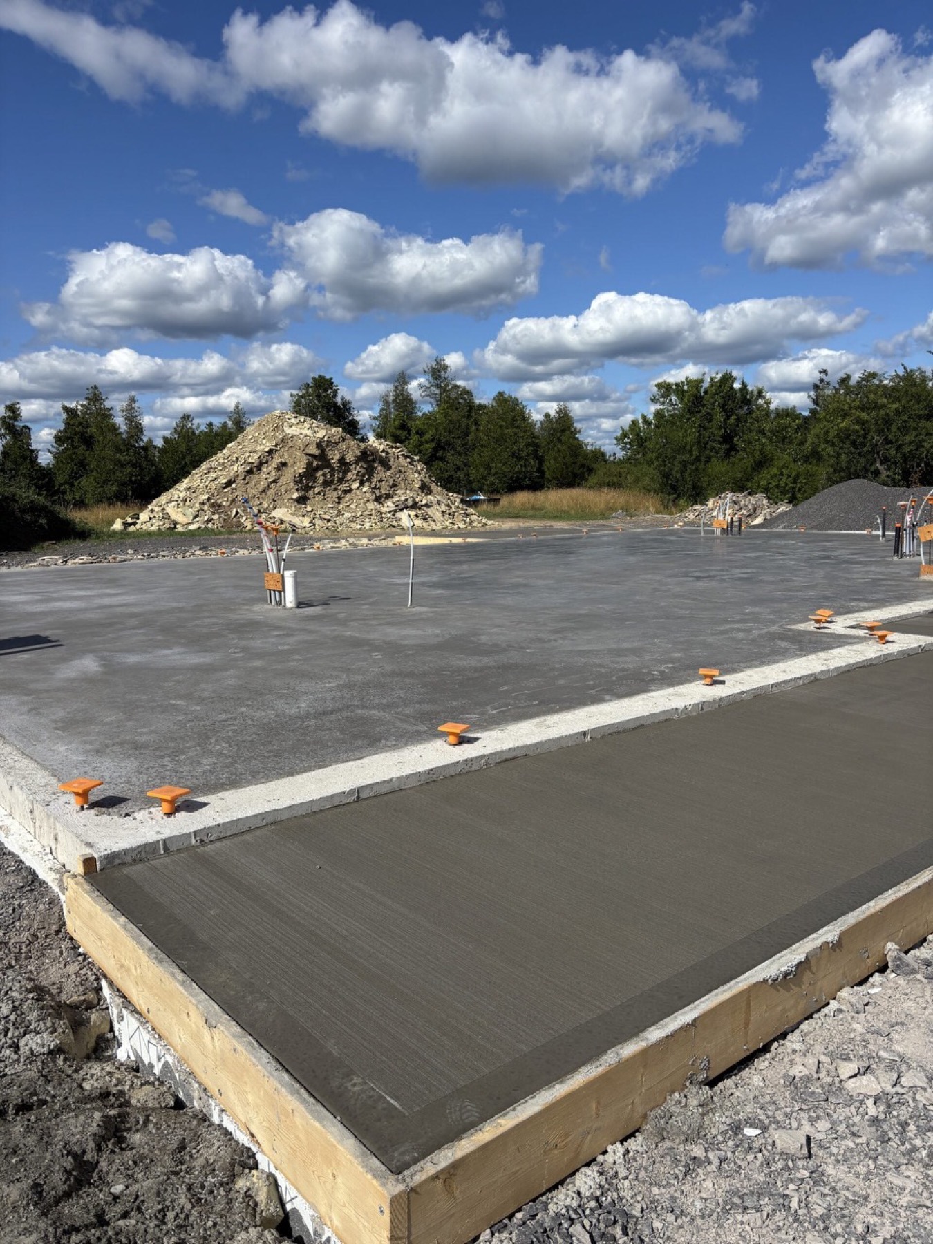 Concrete slab with plumbing rough-ins and edge forms